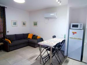 a living room with a couch and a table and a refrigerator at On the sea in Ashkelon