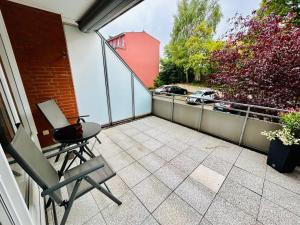 a patio with a table and chairs on a balcony at Ferienwohnung am Klein Kiel in Kiel