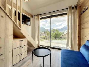 a room with a bed and a table and a window at Petit loft chaleureux et cosy - vue montagne in Guillestre +18 photos