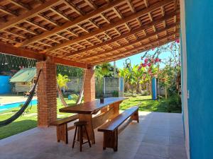 d'une terrasse avec un hamac, une table et des bancs. dans l'établissement Casa de Campo Pedra Bicuda, à Brazópolis