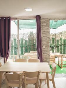 a dining room with a table and chairs and a large window at Apartamento 15' Barcelona centro in Santa Coloma de Gramanet