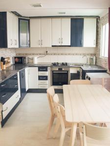 a kitchen with white cabinets and a table and chairs at Apartamento 15' Barcelona centro in Santa Coloma de Gramanet