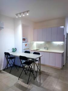 a kitchen with a table and chairs and a sink at On the sea in Ashqelon