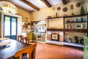 una cucina con tavolo da pranzo e camino di Residenza al Lago a San Maurizio dʼOpaglio Altre 14 foto