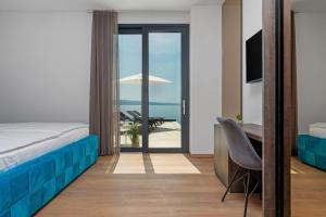 a bedroom with a bed and a desk with a view of the ocean at Villa Prestige in Omiš