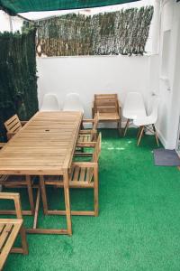 a room with wooden tables and chairs on green carpet at Apartamento 15' Barcelona centro in Santa Coloma de Gramanet
