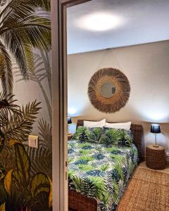 1 dormitorio con cama y espejo en la pared en Appartement hyper central et calme, à 5 mètres de Monaco en Beausoleil