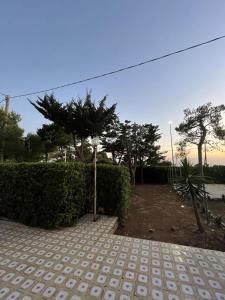 サン・ティジドーロにあるVilla Letizia Sea View in Sant'Isidoroの庭の垣根と木々のある散歩道