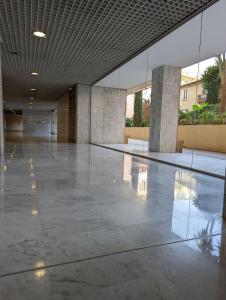 een grote lege kamer met een reflectie van een gebouw bij Appartement hyper central et calme, à 5 mètres de Monaco in Beausoleil