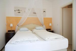 Una cama blanca con dos almohadas encima. en Villa Cartoceto, en Cartoceto