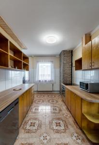a large kitchen with wooden cabinets and a tile floor at Гостинний двір КАРПАТІЯ, Верховина in Verkhovyna