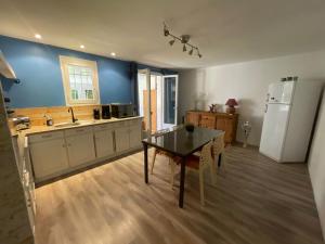 kuchnia ze stołem i białą lodówką w obiekcie Le Cocon des SPRESS w mieście Cers +9 zdjęć