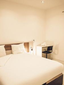 una camera con un grande letto bianco e una scrivania di Apartamento 15' Barcelona centro a Santa Coloma de Gramanet