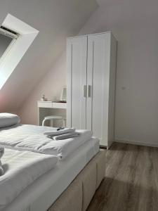 a white bedroom with a bed and a white cabinet at Ferienwohnung Soltau in Soltau