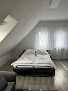 a bed sitting in a room next to two windows at Ferienwohnung Soltau in Soltau