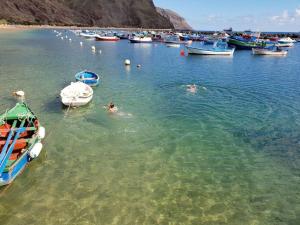 two people swimming in a body of water with boats at Las Teresitas Apartment in San Andrés