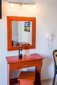 een fles wijn op een houten tafel met een spiegel bij Studios Maria in Potos