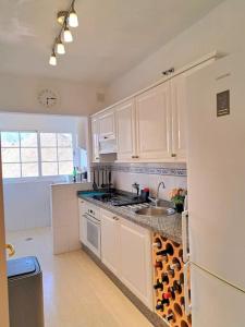 a white kitchen with a sink and a refrigerator at Las Teresitas Apartment in San Andrés