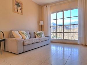 a living room with a couch and a large window at Las Teresitas Apartment in San Andrés