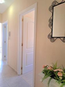 a hallway with a door and a mirror and flowers at Las Teresitas Apartment in San Andrés
