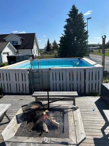 um quintal com uma piscina, uma mesa e uma lareira em The Northern Light Apartment em Jukkasjärvi