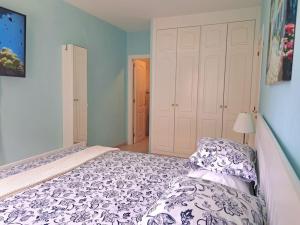 a bedroom with a bed with a white and blue comforter at Las Teresitas Apartment in San Andrés