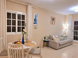 Las Teresitas Apartment في San Andrés: غرفة معيشة مع أريكة وطاولة