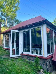 a screened in porch with a roof at ЛІСОВА ХАТИНКА in Kelechin +32 photos