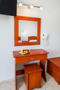 een tafel met een spiegel en een fruitschaal erop bij Studios Maria in Potos