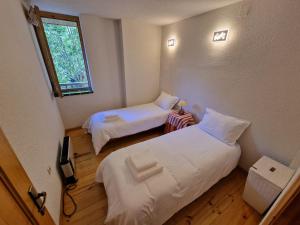 a room with two beds and a television and a window at Apartamento acogedor con vistas in Taull