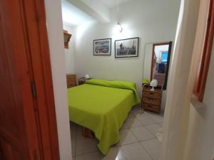 a bedroom with a green bed and a mirror at Favignana Vacanze in Favignana
