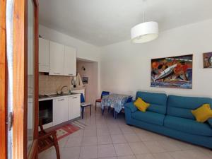 un soggiorno con divano blu e una cucina di Favignana Vacanze a Favignana