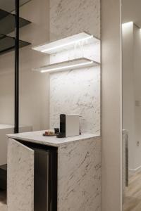 a kitchen with white marble walls and a counter at Nur Aparthotel Athens in Athens