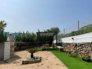 einen Garten mit einer Bank und einer Steinmauer in der Unterkunft Casa Cuartel in Redondela