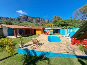 a house with a yard with a swimming pool at Casa de Campo Pedra Bicuda in Brazópolis