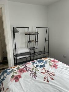a bed with a floral blanket on it with a chair at Middlecroft in Chesterfield