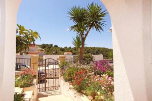 a balcony with flowers and a palm tree at Apartments Prosperina Hvar in Hvar