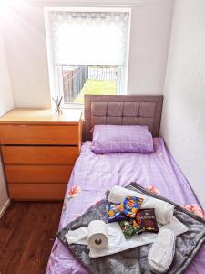 a small bedroom with a purple bed with a window at holiday home in Manchester