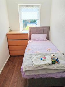 a bedroom with a bed with a dresser and a window at holiday home in Manchester