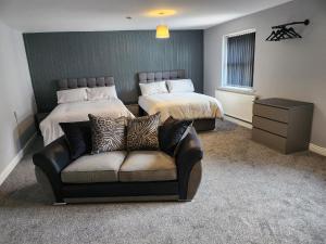 ein Hotelzimmer mit 2 Betten und einem Sofa in der Unterkunft Kings Head in Chepstow