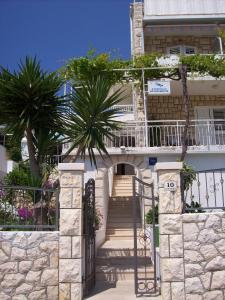 a building with stairs and palm trees in front of it at Apartments Prosperina Hvar in Hvar