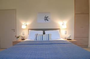 a bedroom with a large blue bed with two pillows at Mylos Apartments in Gialova