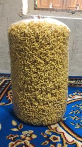 un vaso pieno di spaghetti, seduto su un tappeto. di Tapian Ratu Camp a Bukittinggi