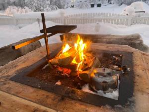 a fire pit in a yard with snow at The Northern Light Apartment in Jukkasjärvi