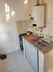 a kitchen with a sink and a stove at Departamento Payún Matrú in Malargüe