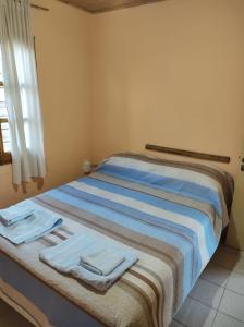 ein Schlafzimmer mit einem Bett mit Handtüchern darauf in der Unterkunft Departamento Payún Matrú in Malargüe