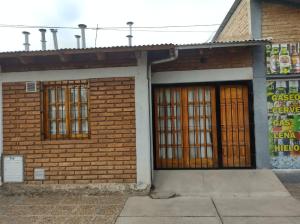 a brick building with two doors and a sign on it at Departamento Payún Matrú in Malargüe