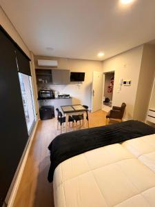 1 dormitorio con 1 cama y cocina con mesa en 1-6 Monoambiente capital, amplio, luminoso y acogedor en Buenos Aires