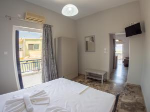 um quarto com uma cama branca e uma varanda em Pavlopetri em Vingláfia