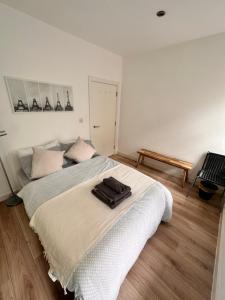 Modern 2 bedroom flat next to Liverpool Street في لندن: غرفة نوم مع سرير أبيض كبير مع لاب توب عليها